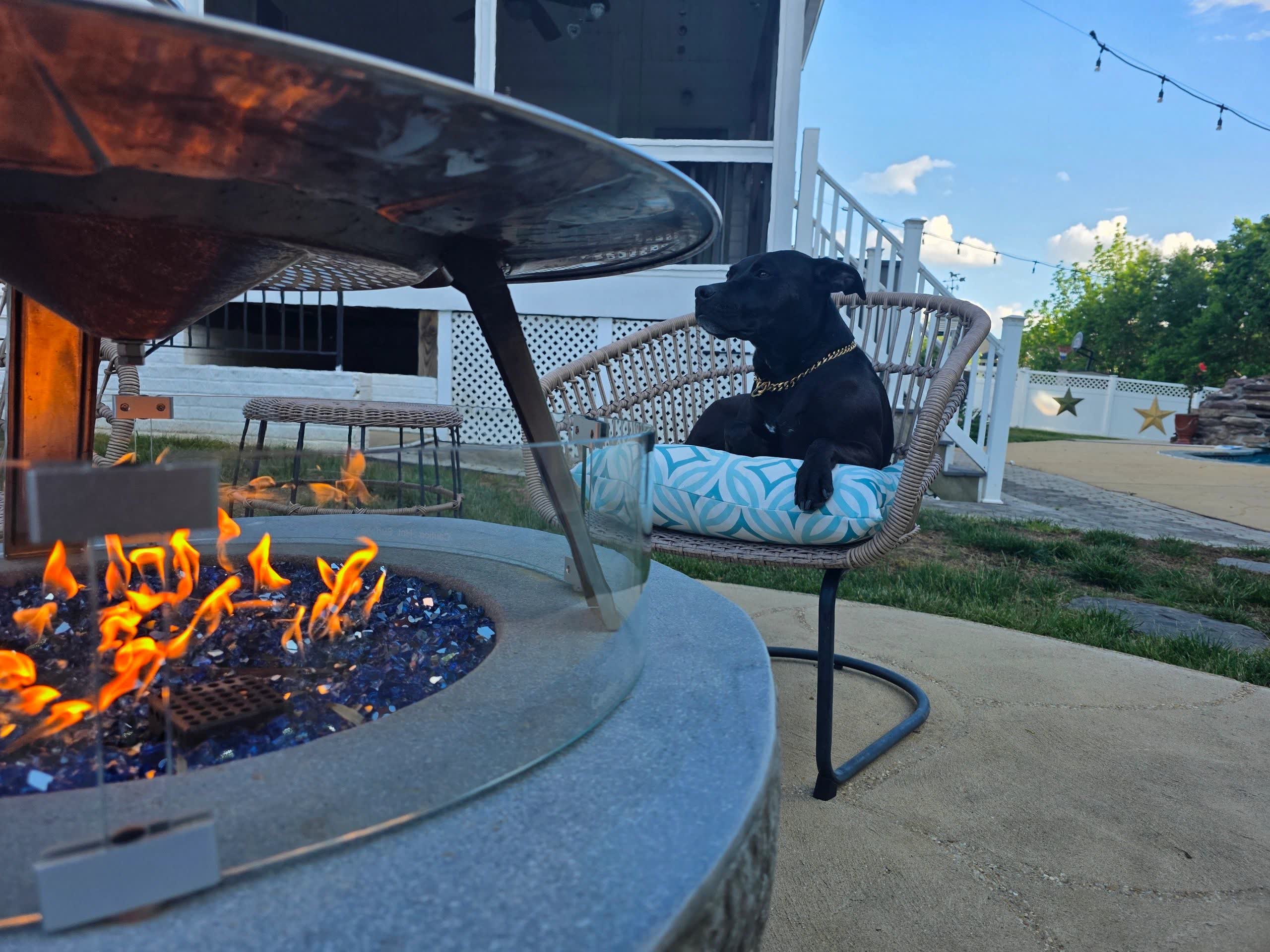 Solo Stove fire pit with heat deflector glowing in a backyard at dusk