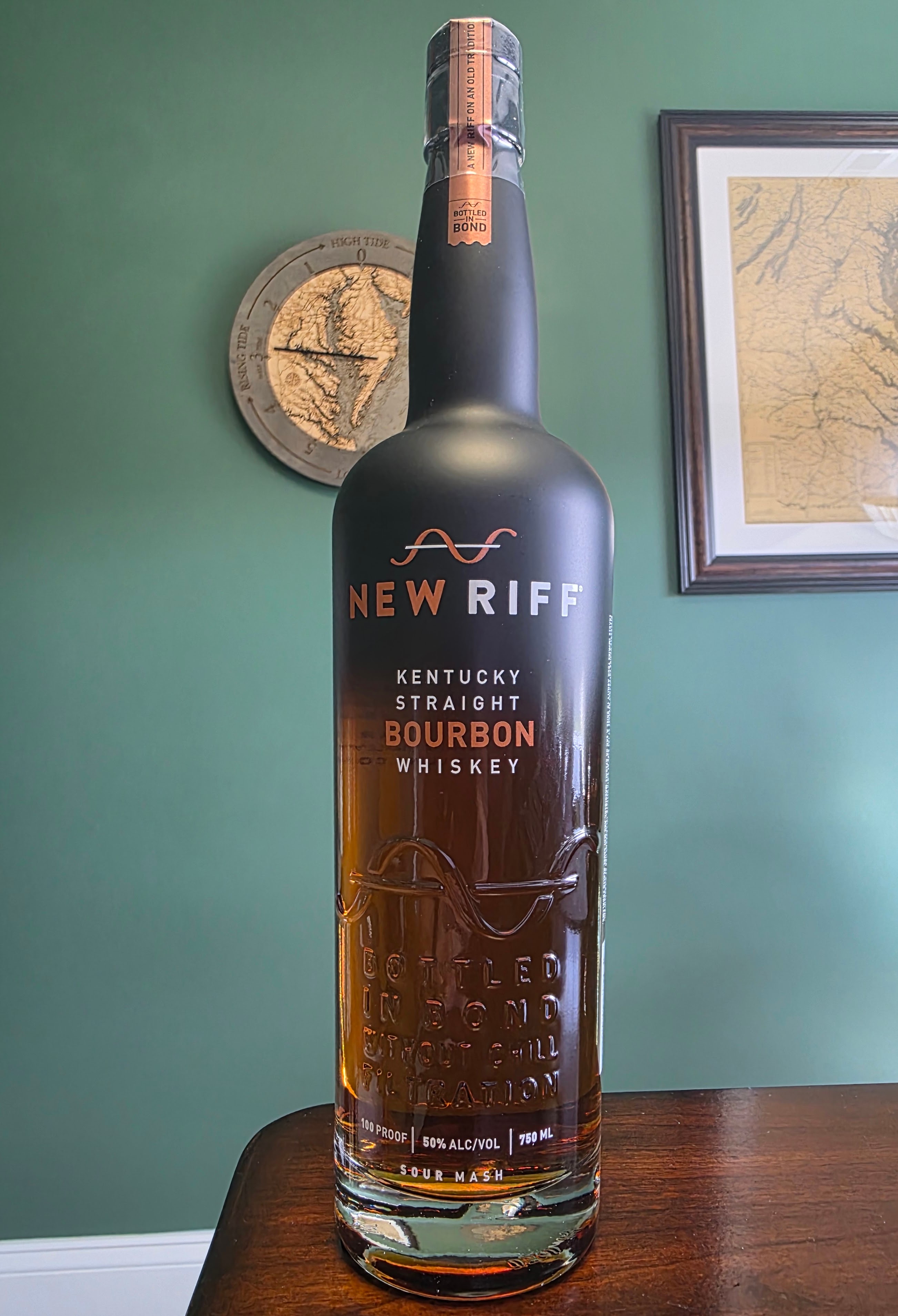 New Riff Bottled-in-Bond bottle on wood with High Tide clock behind it