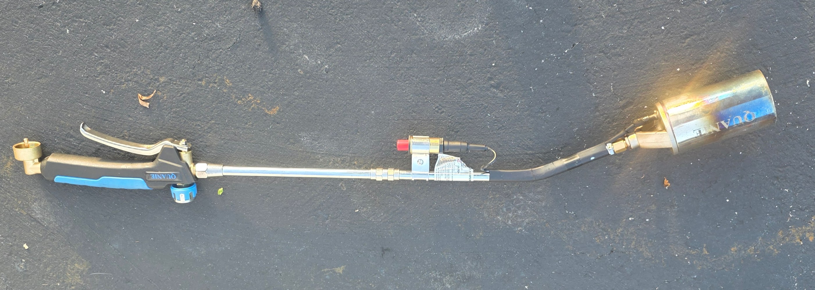 Quanie propane torch full length on asphalt, QUANIE on burner head