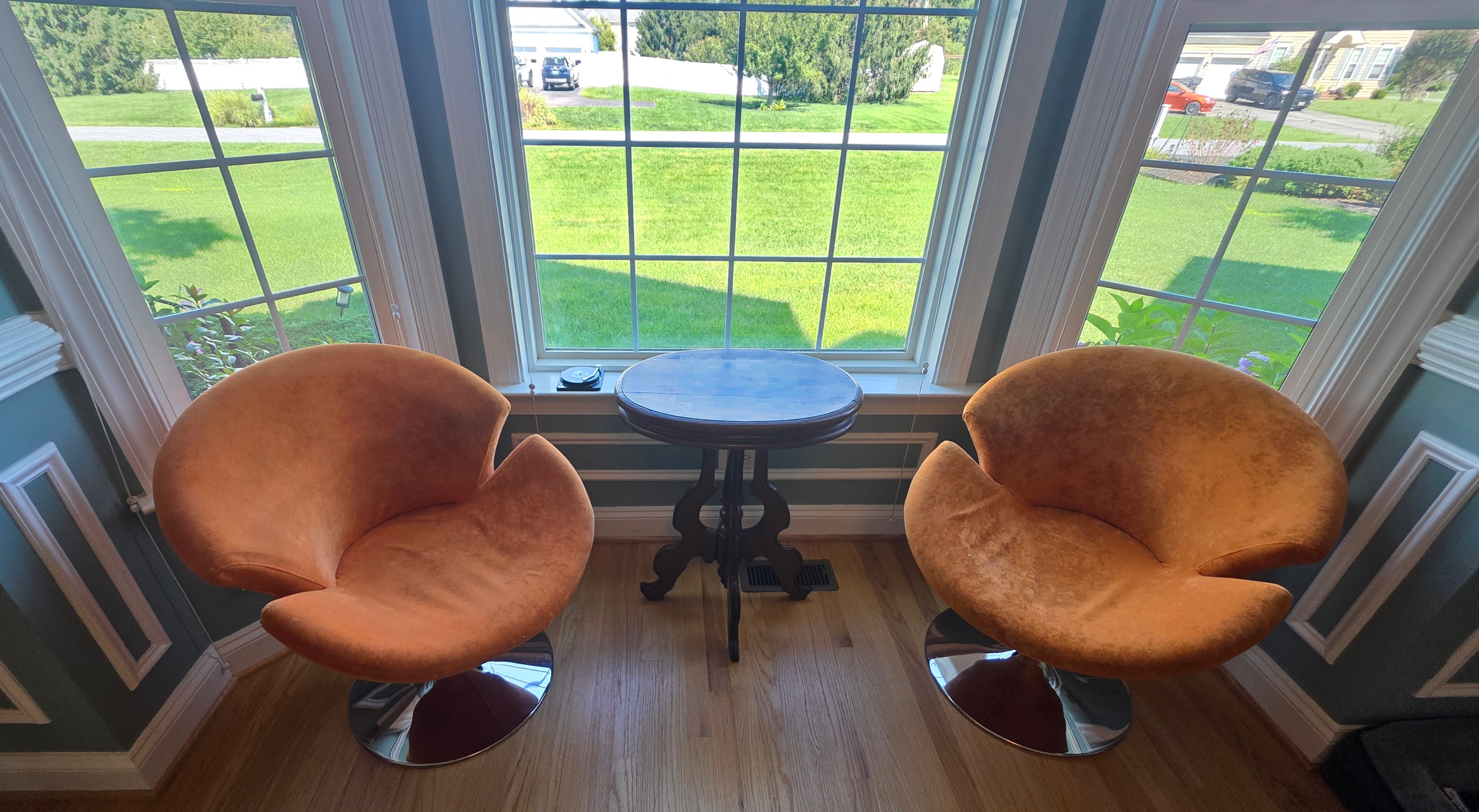 Orange velvet swivel chairs facing the bay window in the parlor